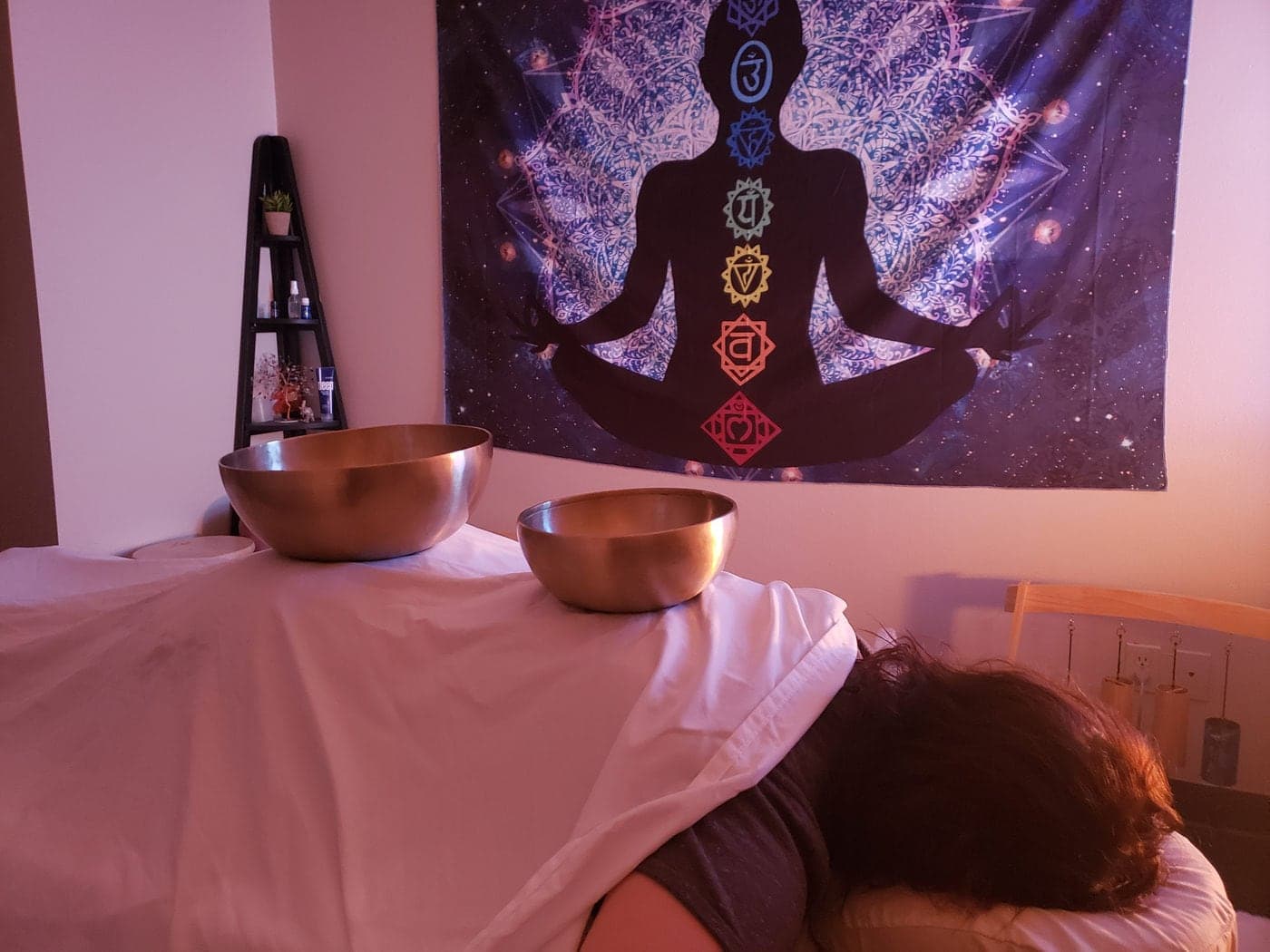 Flora placing singing bowls during a vibrational sound therapy session