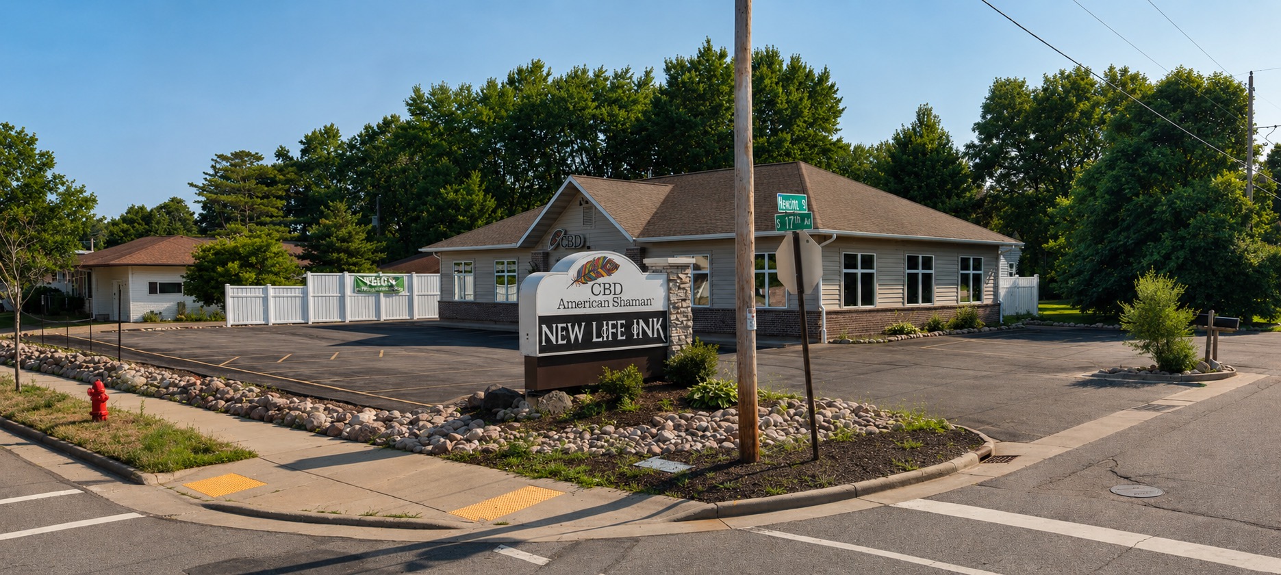Exterior of New Life Ink at the corner of Hewitt Street and South 17th Avenue in Wausau, Wisconsin, with the studio's monument sign out front.